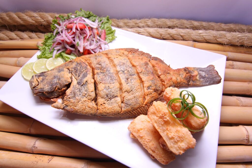Pescado fresco frito al punto, crujiente por fuera y tierno por dentro, servido con yuca dorada y arroz blanco. Un plato clásico, sabroso y muy completo.