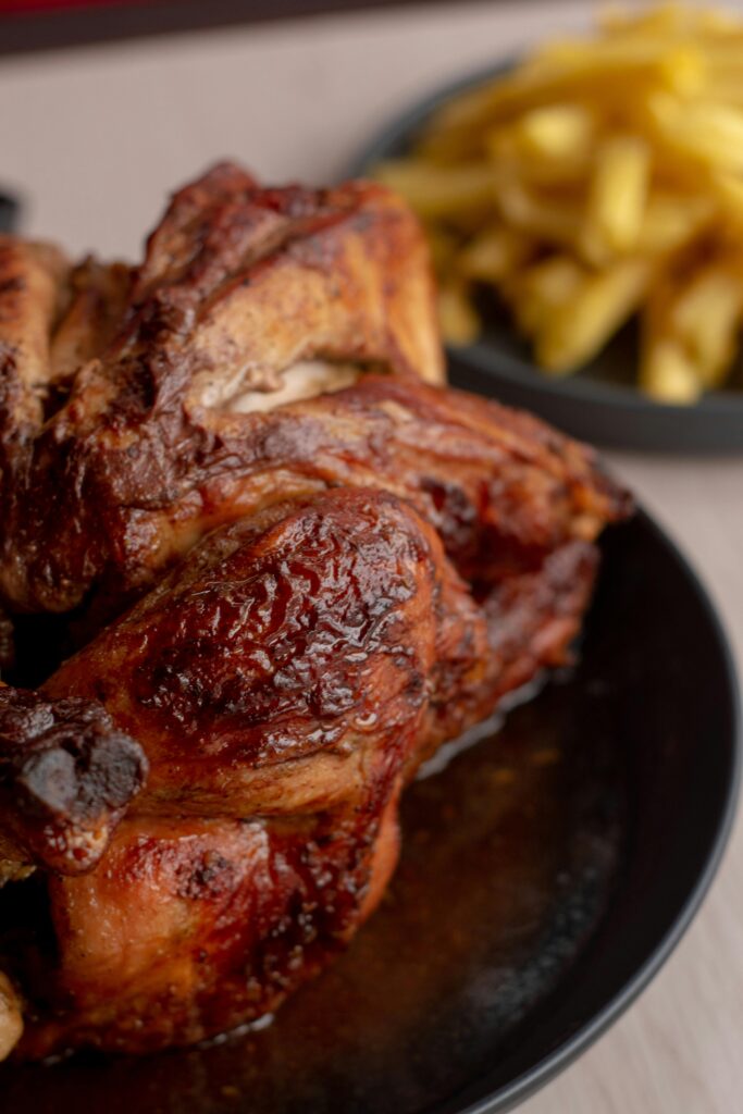 Pollo al carbón Jugoso pollo marinado con especias peruanas y asado al carbón para lograr un sabor ahumado inconfundible. Acompañado de guarnición tradicional.